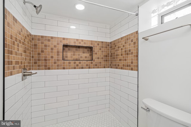 full bath with toilet and a tile shower