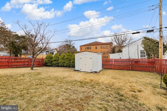 view of yard featuring an outbuilding, a fenced backyard, and a shed