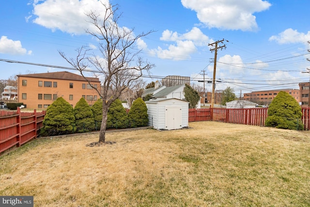 view of yard featuring a shed, an outdoor structure, and a fenced backyard