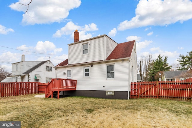 rear view of house featuring a fenced backyard, a yard, roof with shingles, a wooden deck, and a chimney