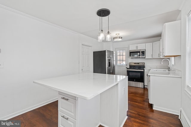 kitchen with a sink, dark wood-style floors, a center island, white cabinetry, and appliances with stainless steel finishes