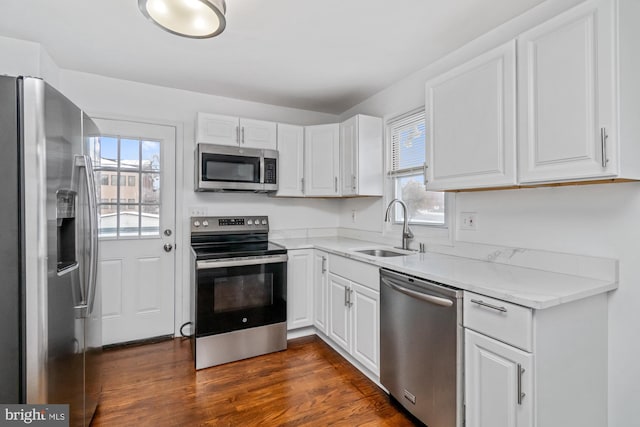 kitchen featuring a sink, stainless steel appliances, white cabinets, and dark wood-style flooring