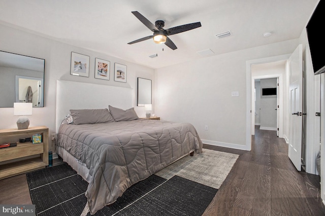 bedroom with a ceiling fan, visible vents, baseboards, and wood finished floors