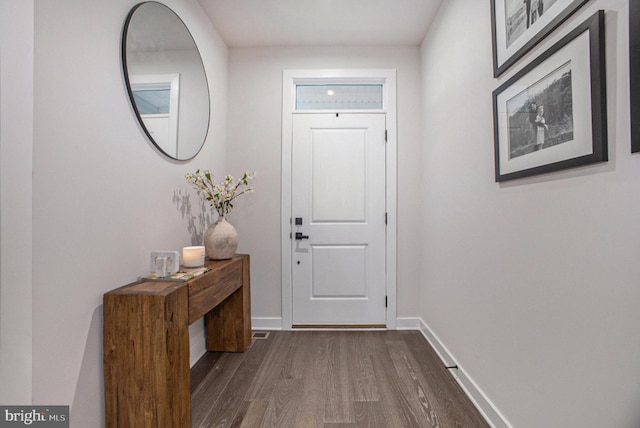 entryway with dark wood-style floors and baseboards