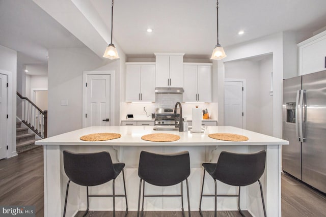 kitchen with white cabinets, decorative backsplash, stainless steel appliances, light countertops, and under cabinet range hood