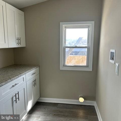 laundry area with dark wood-type flooring, hookup for a washing machine, and baseboards