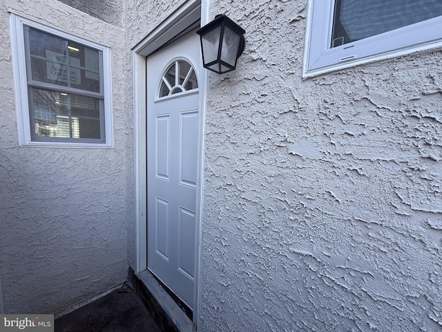 view of exterior entry with stucco siding