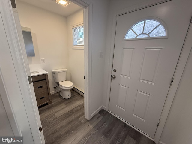 bathroom featuring toilet, wood finished floors, vanity, baseboards, and baseboard heating