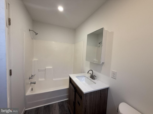 bathroom featuring shower / bathing tub combination, vanity, toilet, and wood finished floors