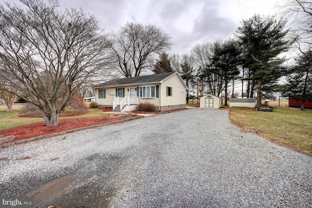 view of front of property with a front lawn, an outbuilding, gravel driveway, and crawl space