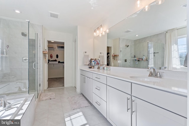 full bath featuring a stall shower, a spacious closet, visible vents, and a sink