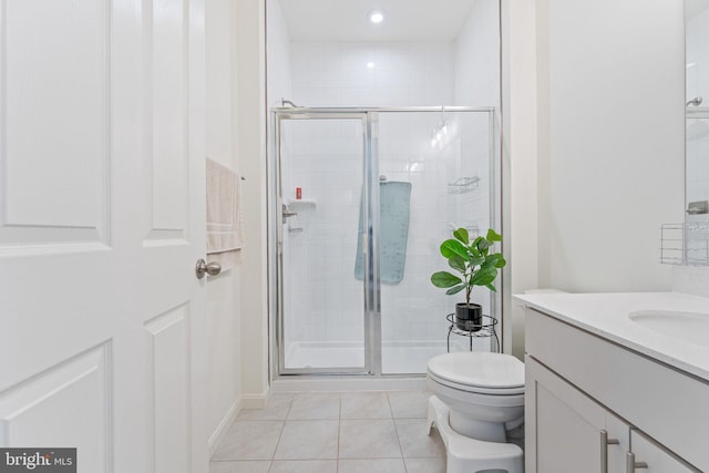 bathroom with vanity, tile patterned flooring, a shower stall, and toilet