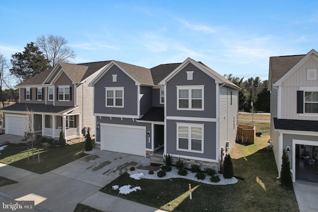 traditional-style home featuring a front yard, driveway, and an attached garage