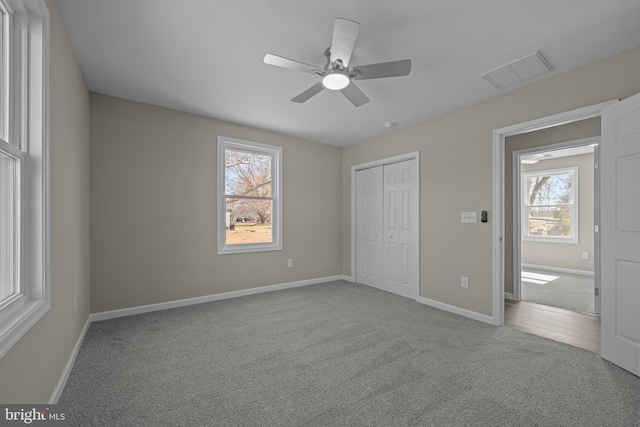 unfurnished bedroom featuring carpet, a closet, visible vents, ceiling fan, and baseboards