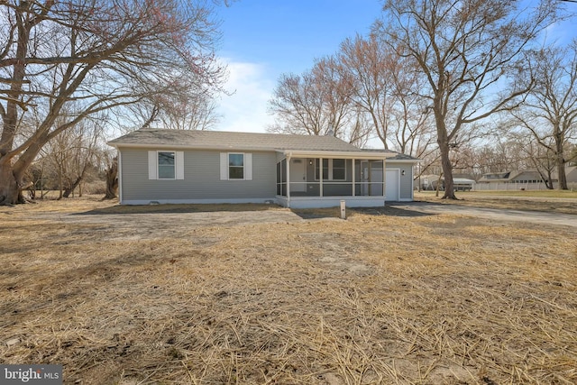 ranch-style house with a garage and a sunroom