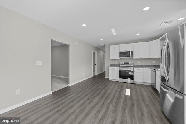 kitchen featuring recessed lighting, appliances with stainless steel finishes, white cabinetry, wood finished floors, and baseboards