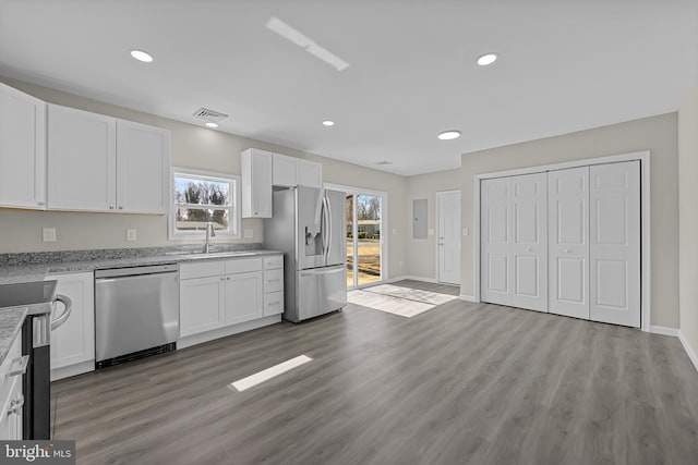 kitchen with appliances with stainless steel finishes, visible vents, a sink, and white cabinetry