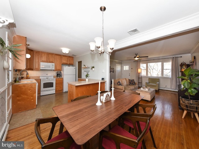 dining area featuring ornamental molding, wood finished floors, and visible vents