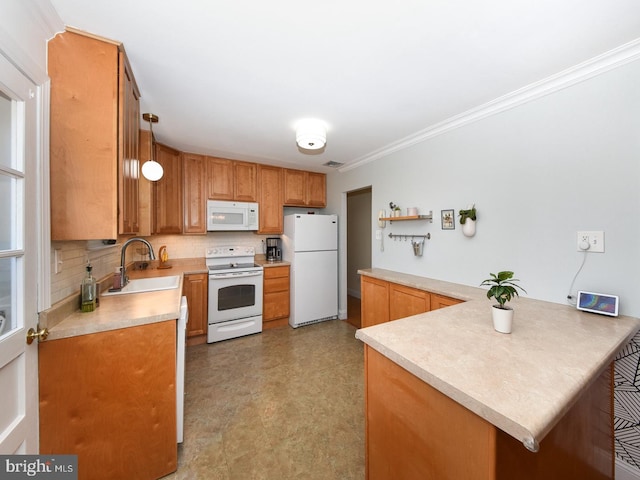 kitchen with crown molding, light countertops, a sink, white appliances, and a peninsula