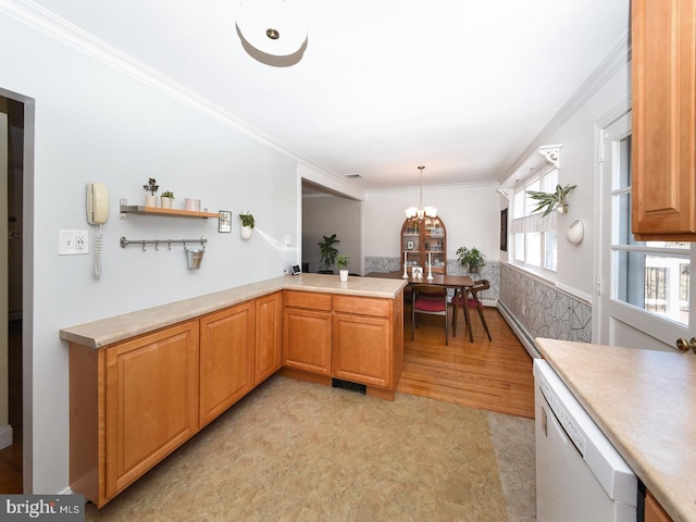 kitchen featuring dishwasher, light countertops, decorative light fixtures, and crown molding