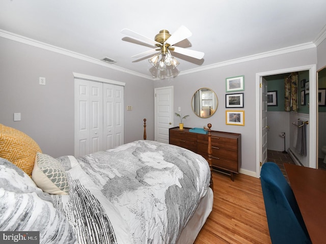 bedroom with ornamental molding, a closet, visible vents, and light wood-style floors