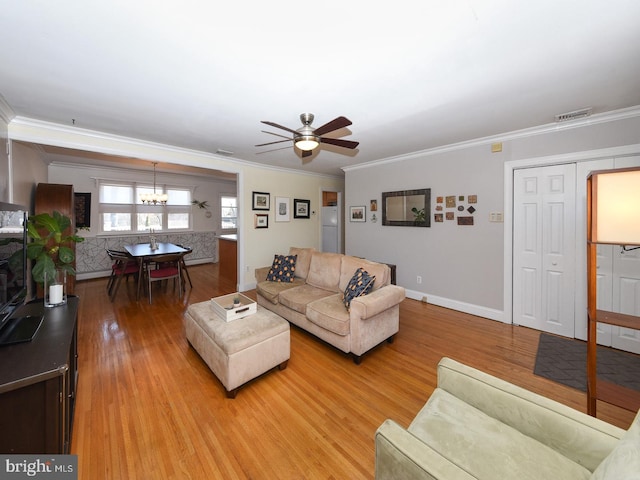 living room featuring baseboards, ceiling fan with notable chandelier, light wood-type flooring, and crown molding