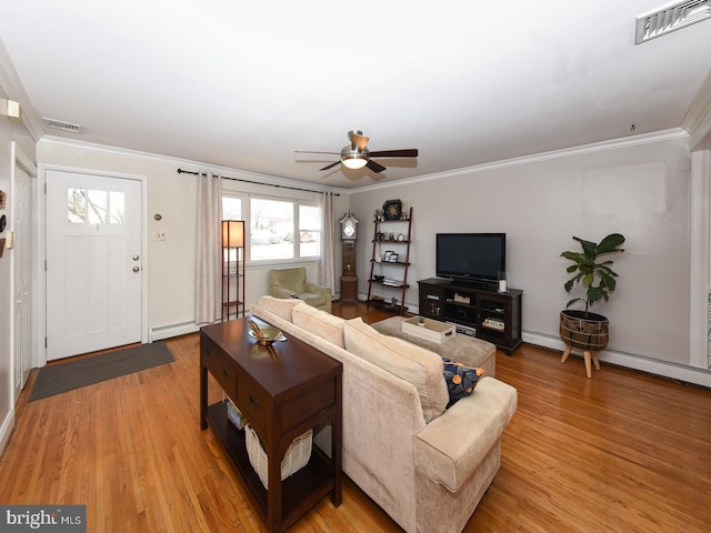 living area with light wood-type flooring, a baseboard radiator, visible vents, and ornamental molding