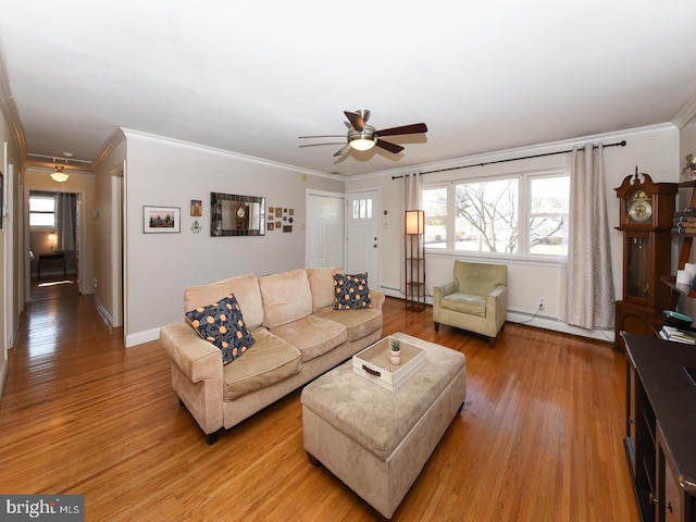 living area featuring light wood-type flooring, crown molding, baseboard heating, and ceiling fan