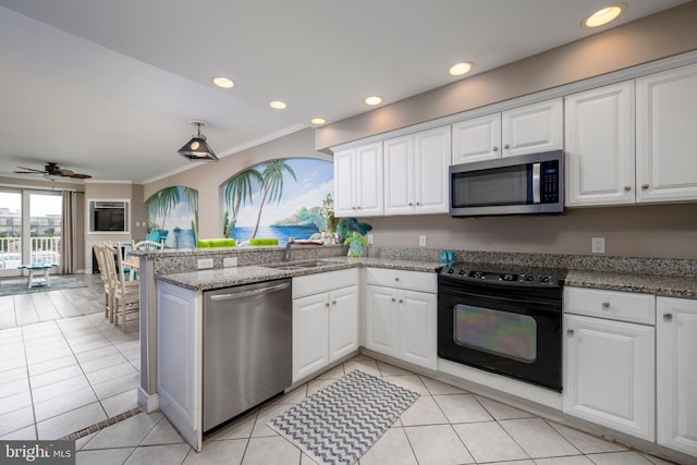 kitchen featuring appliances with stainless steel finishes, white cabinets, and a sink