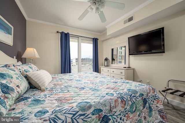 bedroom with baseboards, visible vents, wood finished floors, and ornamental molding