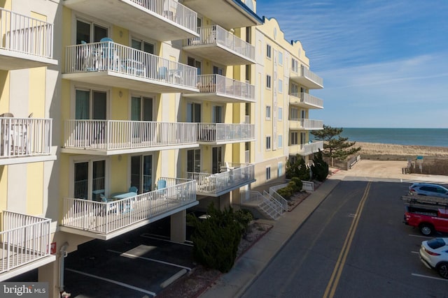 view of building exterior featuring a water view and a view of the beach