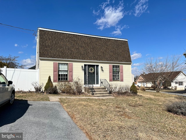 view of front of property with a shingled roof and fence