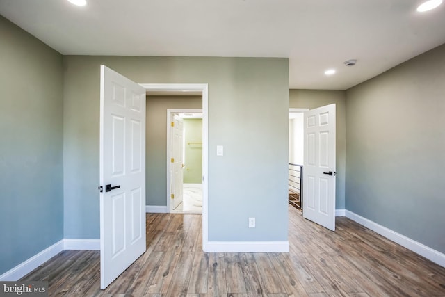 unfurnished bedroom featuring recessed lighting, baseboards, and wood finished floors