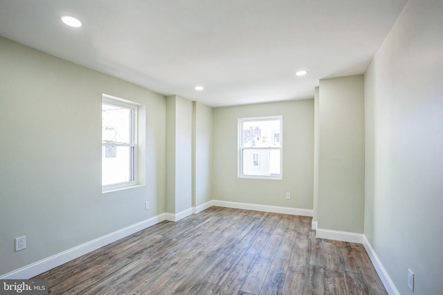 unfurnished room with recessed lighting, baseboards, plenty of natural light, and wood finished floors