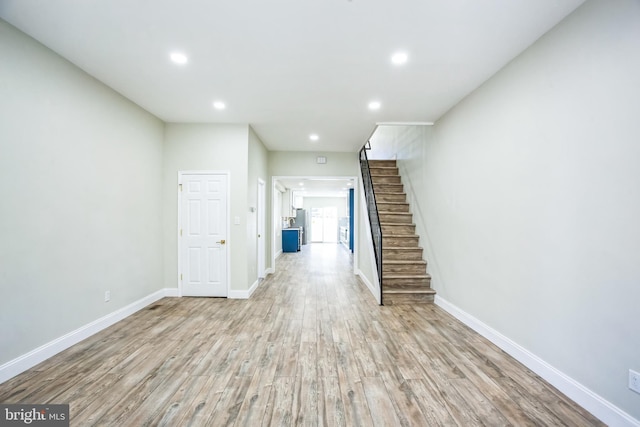 interior space with recessed lighting, baseboards, wood finished floors, and stairs