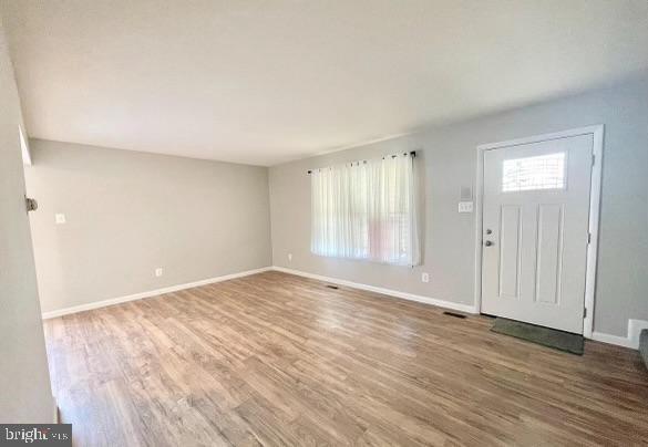 entrance foyer featuring baseboards and wood finished floors