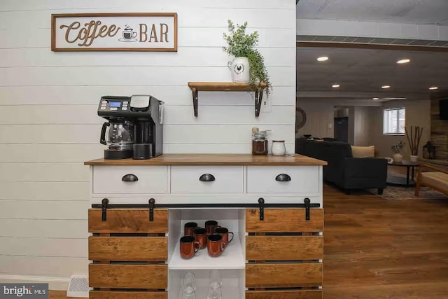 bar with dark wood-style floors, recessed lighting, and a barn door