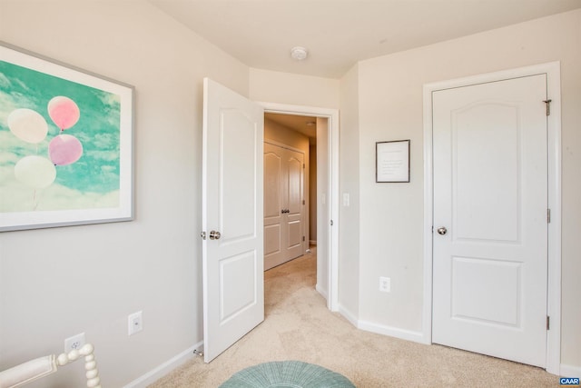 unfurnished bedroom featuring light carpet and baseboards