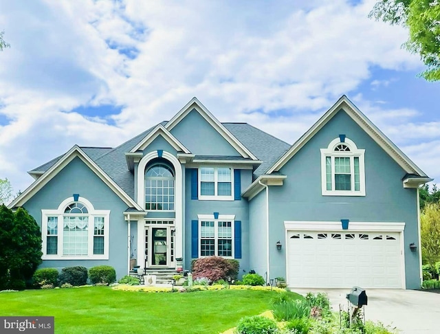 traditional home featuring concrete driveway, an attached garage, a front lawn, and stucco siding