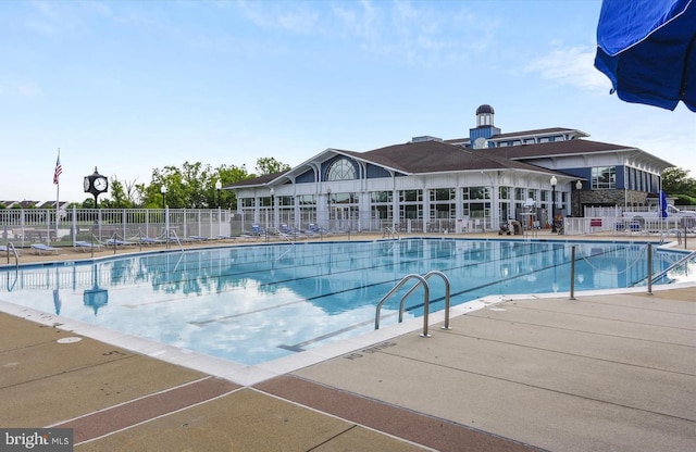 pool with a patio and fence