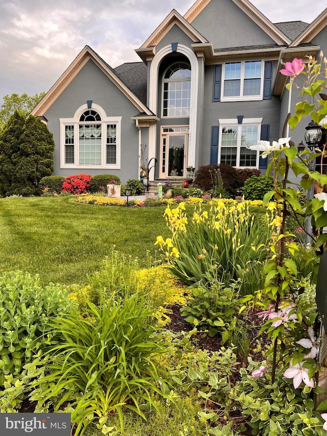 view of front of house featuring stucco siding and a front lawn