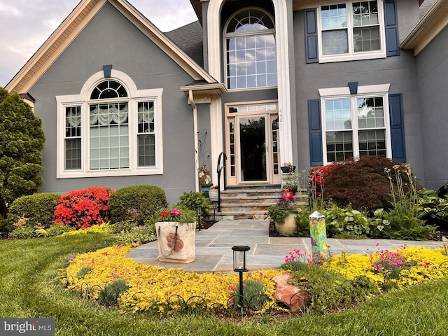 doorway to property featuring stucco siding