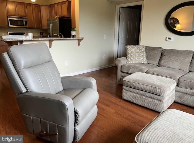 living area featuring dark wood-type flooring and baseboards