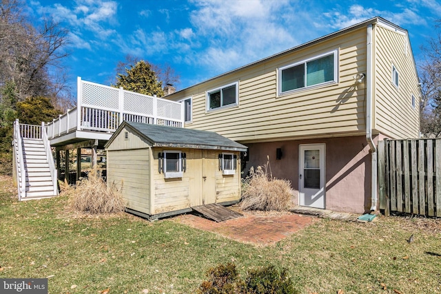 back of property with a storage shed, stairway, an outbuilding, fence, and a yard