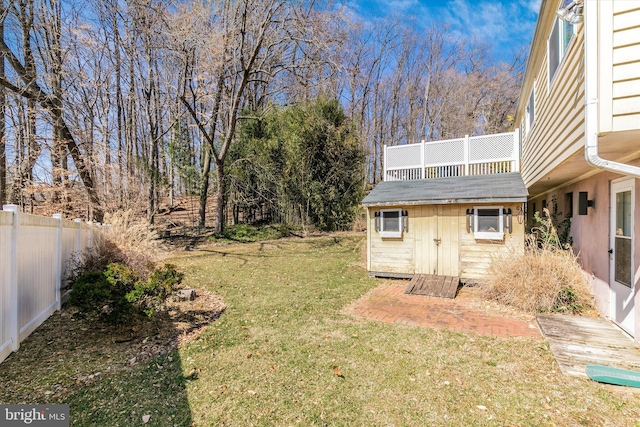 view of yard with a storage shed, an outdoor structure, and fence