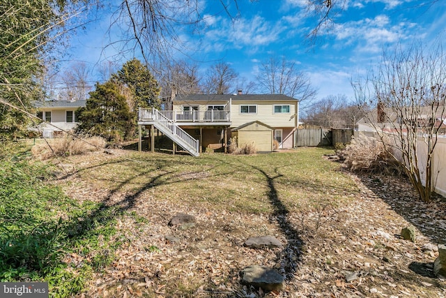 back of property with a chimney, stairway, an outbuilding, fence, and a wooden deck