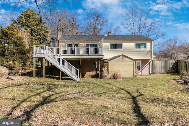 rear view of property featuring a deck, fence, a yard, stairway, and a chimney