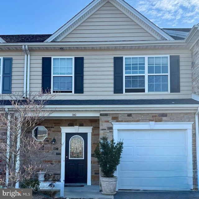 view of front of home featuring stone siding and an attached garage