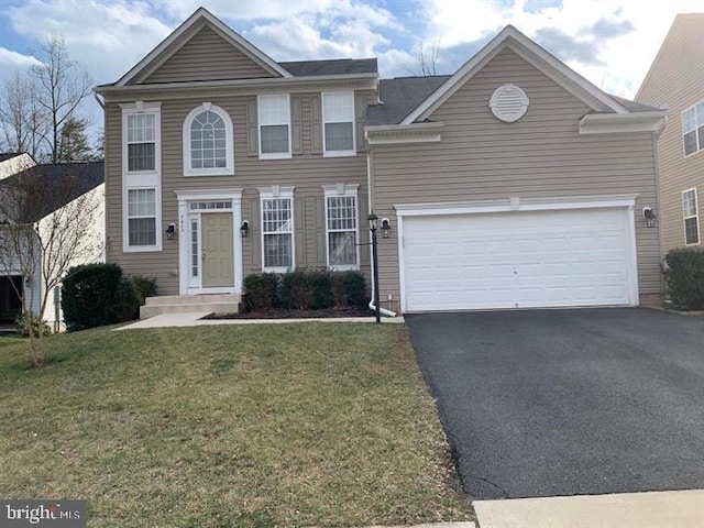 view of front of home featuring a garage, a front yard, and driveway