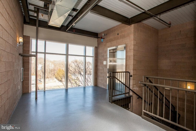 interior space featuring beamed ceiling and elevator